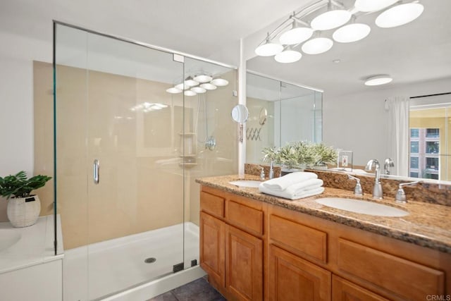 bathroom with double vanity, a shower stall, and a sink