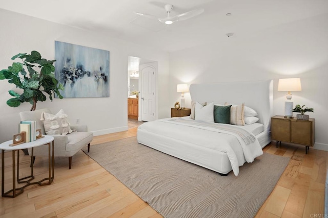 bedroom featuring ensuite bathroom, wood finished floors, and baseboards