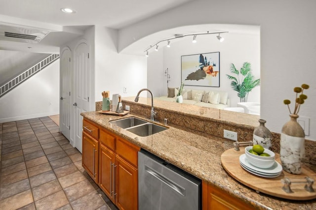 kitchen featuring a sink, visible vents, stainless steel dishwasher, light stone countertops, and brown cabinetry