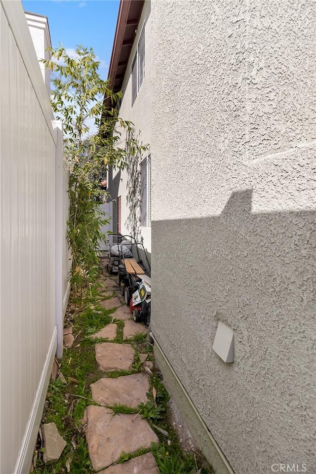 view of home's exterior with fence and stucco siding