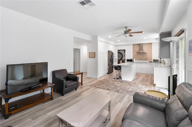 living area with recessed lighting, a ceiling fan, baseboards, visible vents, and light wood finished floors