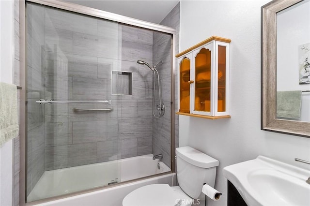 full bath featuring toilet, shower / bath combination with glass door, and a sink