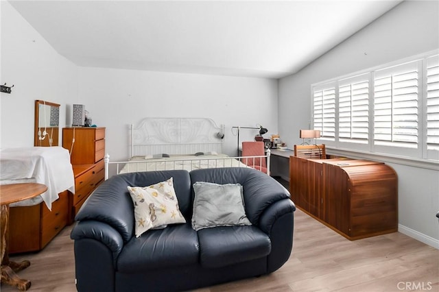 bedroom with lofted ceiling, wood finished floors, and baseboards