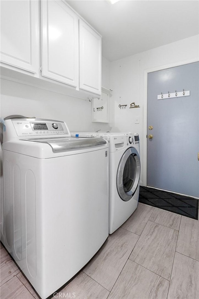 washroom featuring cabinet space and washing machine and dryer