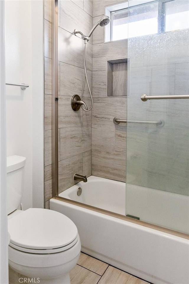 bathroom with shower / bath combination with glass door, wood finished floors, and toilet