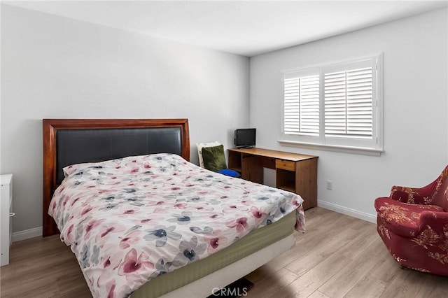 bedroom featuring baseboards and wood finished floors