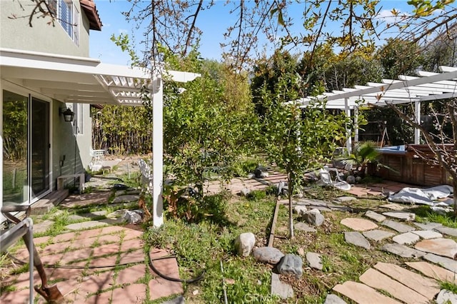 view of yard with a hot tub, a pergola, and a patio