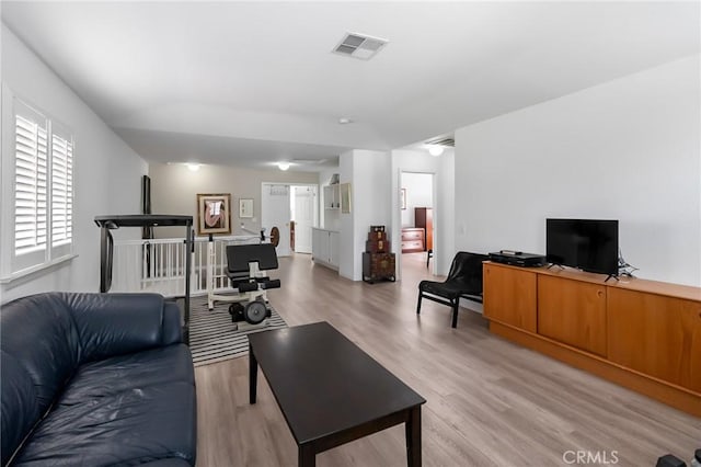 living area featuring light wood-style flooring and visible vents