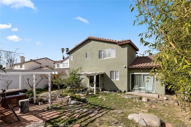 rear view of house featuring fence, a patio area, a tile roof, and stucco siding