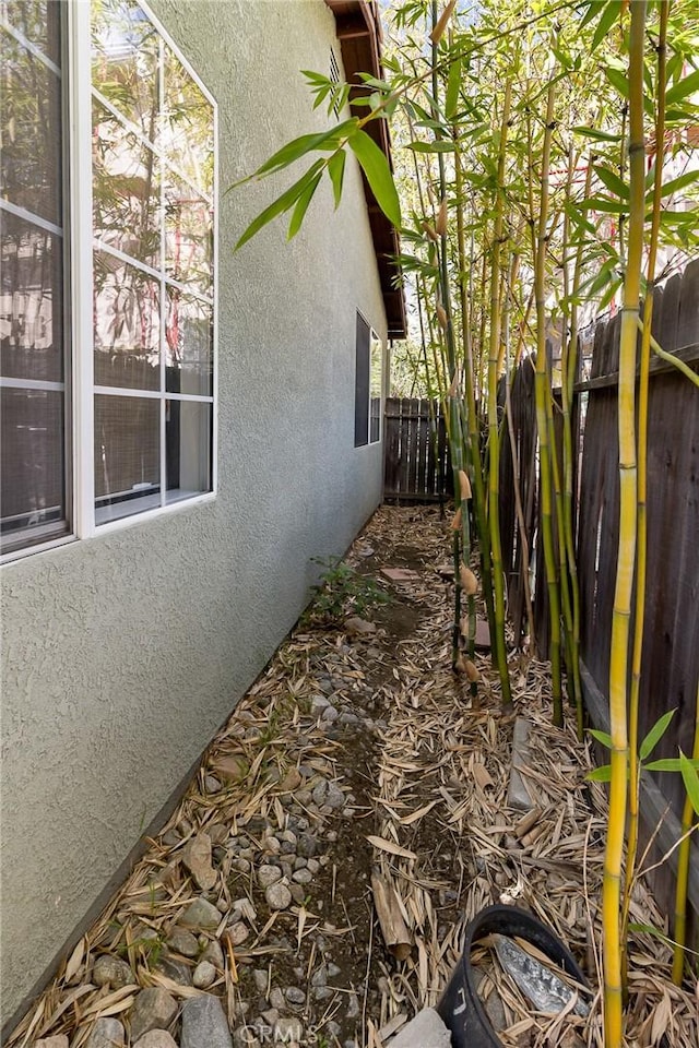 view of property exterior with fence and stucco siding