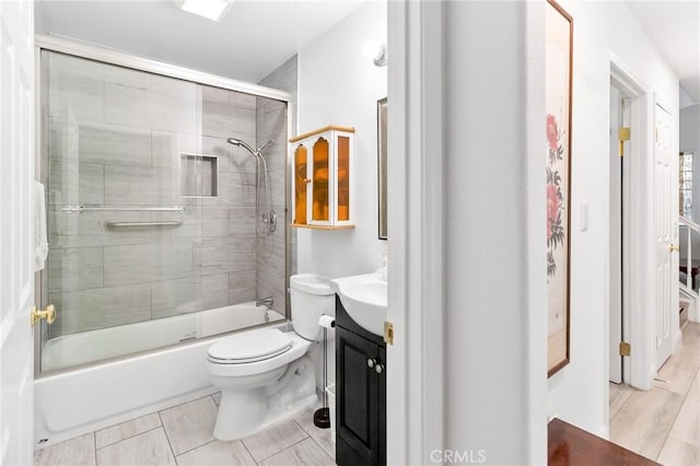 bathroom with toilet, shower / bath combination with glass door, and vanity