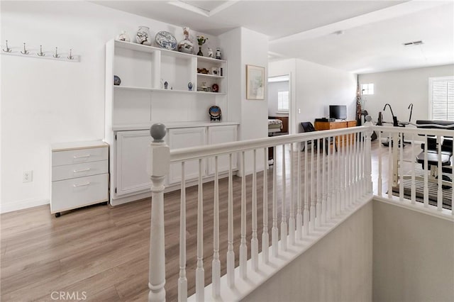 interior space with light wood finished floors, an upstairs landing, and visible vents