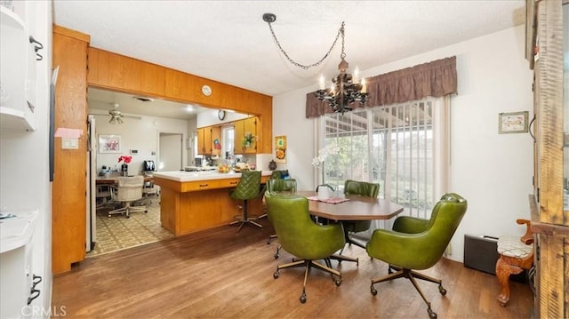 dining area with light wood-style floors, a chandelier, and wood walls