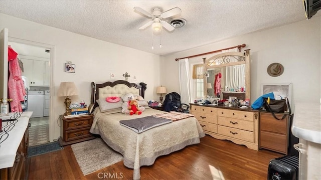 bedroom featuring a textured ceiling, visible vents, wood finished floors, and washing machine and clothes dryer