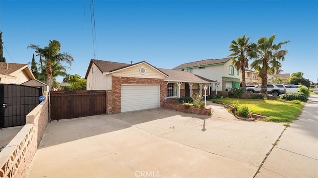 view of front of home with a garage, brick siding, fence, concrete driveway, and a gate