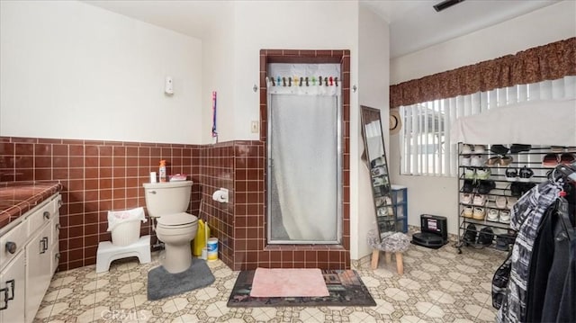 17043 Randall Ave, Fontana, CA 92335 - full bath featuring toilet, wainscoting, tile walls, a shower stall, and vanity