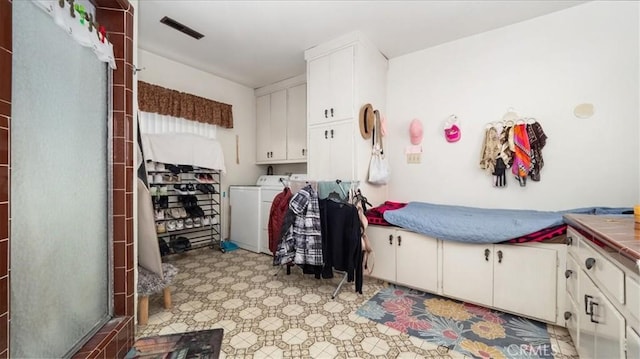 interior space with visible vents, white cabinetry, washer and clothes dryer, and light floors