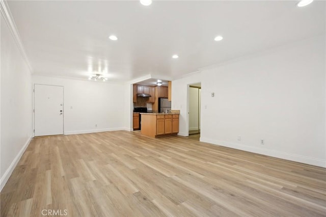 unfurnished living room featuring light wood-style flooring, baseboards, and crown molding