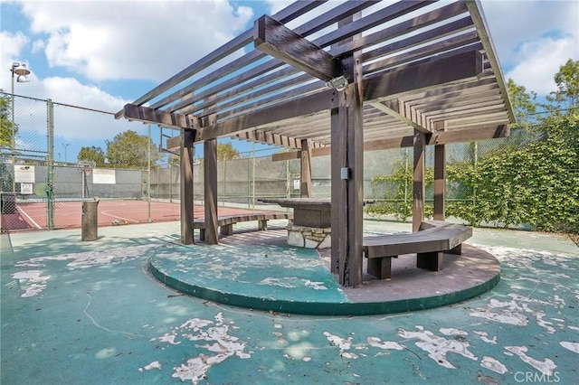 view of property's community with community basketball court, fence, and a pergola