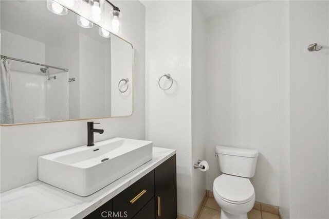 bathroom with toilet, a shower with curtain, tile patterned floors, and vanity