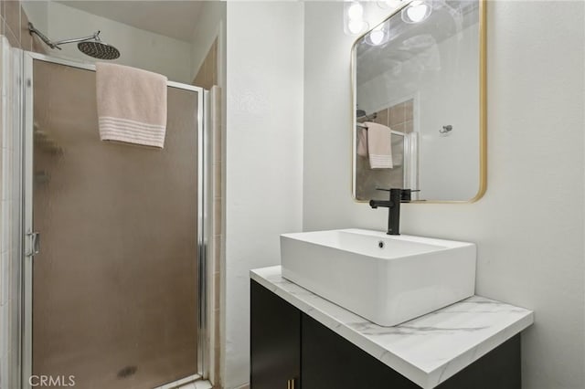 bathroom with a shower stall and vanity