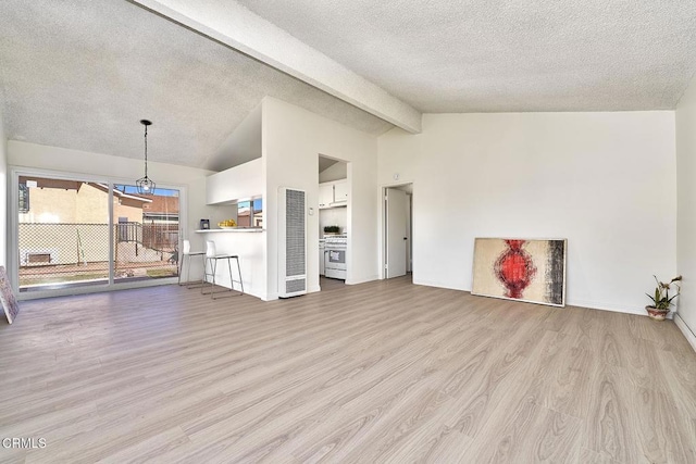 unfurnished living room with lofted ceiling with beams, a textured ceiling, and wood finished floors