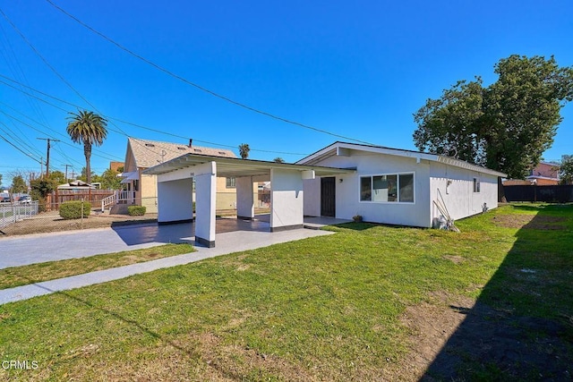 view of front facade featuring stucco siding, a front yard, a patio area, fence, and driveway