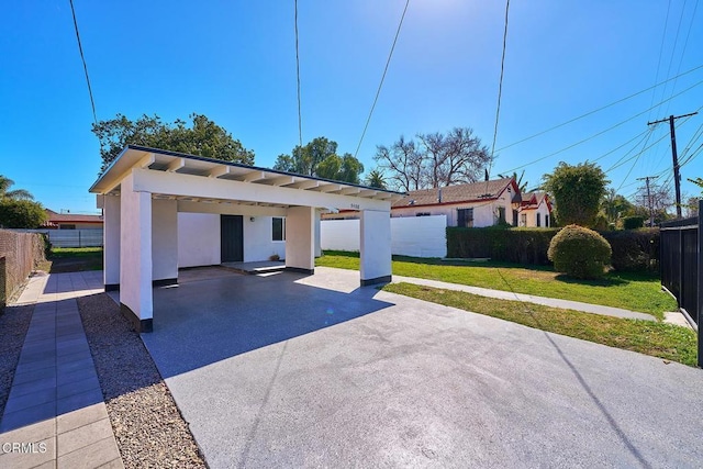 view of front of home with stucco siding, fence, and a front yard