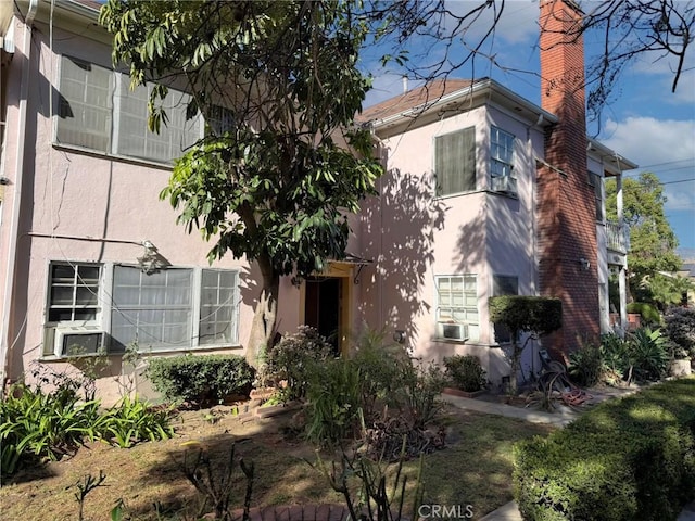 view of front of property featuring a chimney and stucco siding