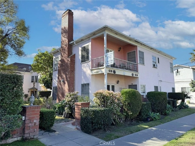 exterior space featuring a chimney and stucco siding