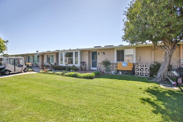 ranch-style house with a front lawn and stucco siding