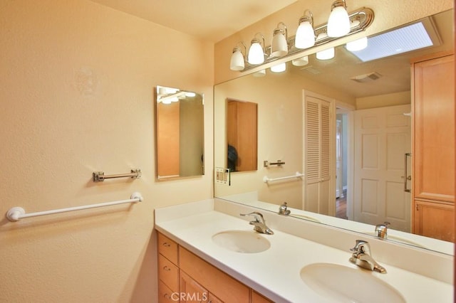 full bath with double vanity, visible vents, and a sink