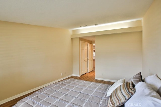 bedroom featuring visible vents, wood finished floors, and baseboards