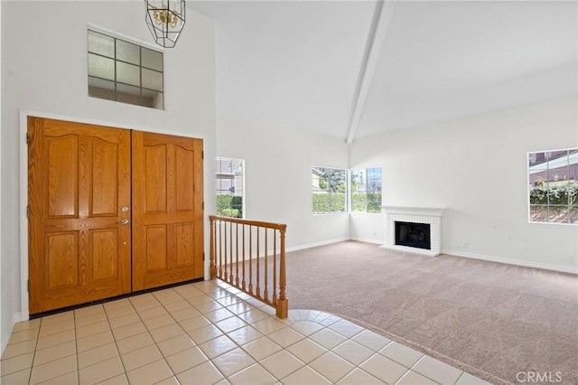 foyer entrance featuring a brick fireplace, light carpet, high vaulted ceiling, beamed ceiling, and baseboards