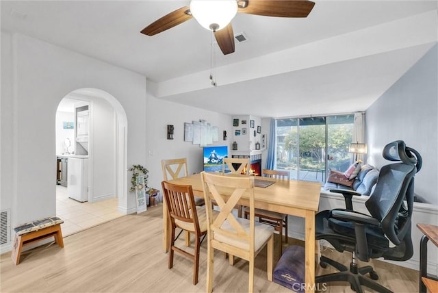 dining room with a ceiling fan, visible vents, light wood-style floors, and arched walkways