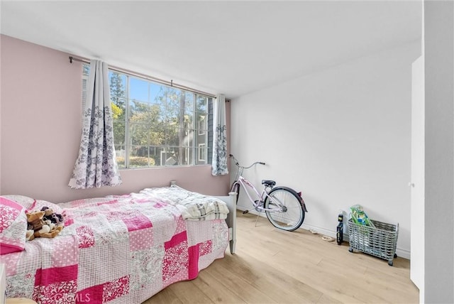 bedroom featuring wood finished floors and baseboards