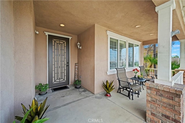 entrance to property with stucco siding and covered porch