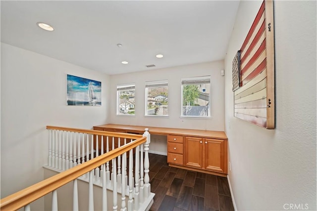 hallway featuring wood finish floors, baseboards, and recessed lighting