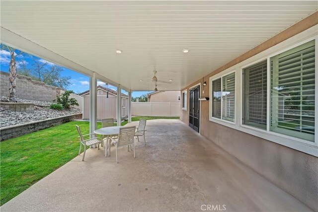 view of patio with a storage shed, outdoor dining area, an outbuilding, and a fenced backyard