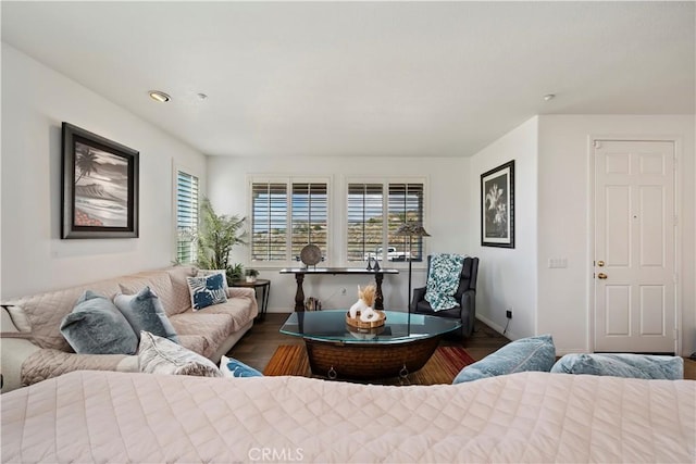 living area with baseboards and wood finished floors