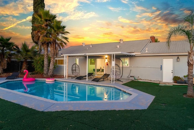 pool with a patio area and a lawn