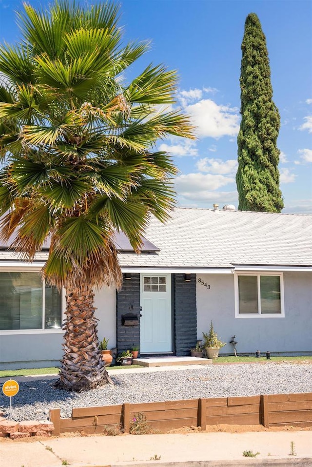 view of front of property with roof with shingles and stucco siding