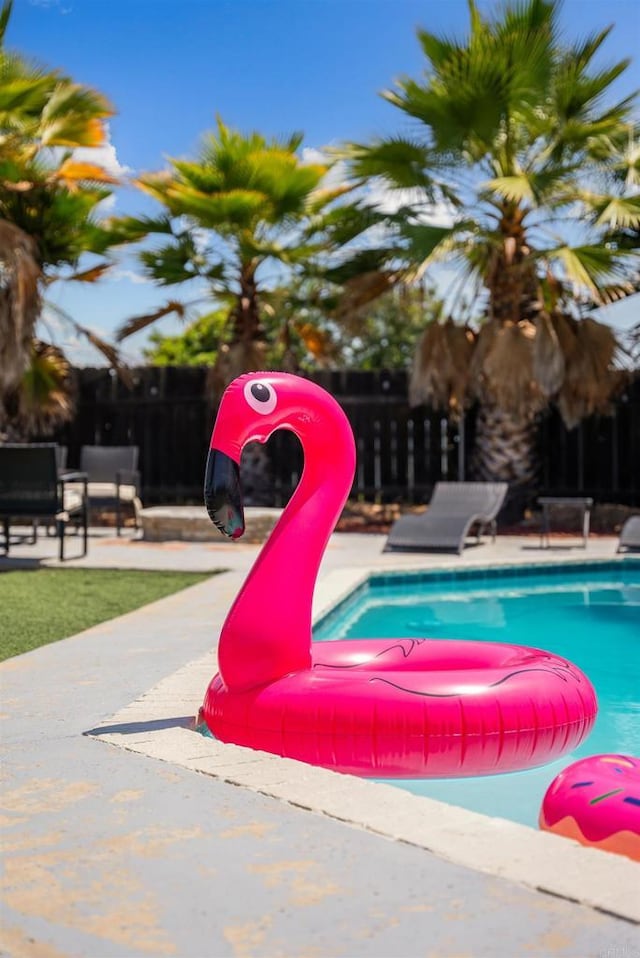 outdoor pool featuring a patio area and fence