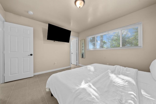 tiled bedroom featuring baseboards