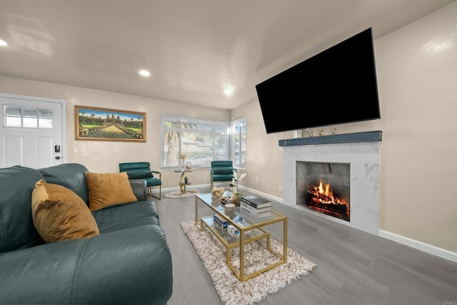 living area featuring a fireplace, baseboards, wood finished floors, and recessed lighting