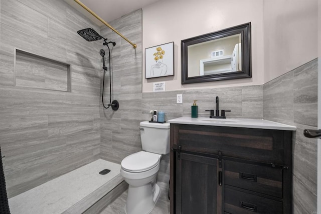 full bathroom with tile walls, visible vents, toilet, vanity, and tiled shower