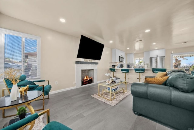 living area featuring a wealth of natural light, baseboards, and recessed lighting