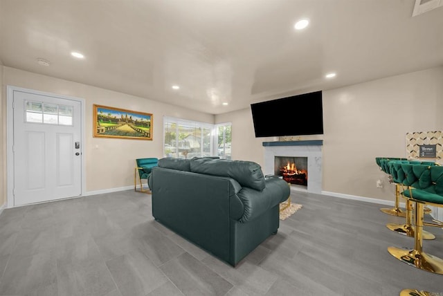 living area with recessed lighting, visible vents, a fireplace, and baseboards