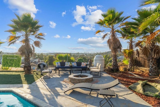 view of patio / terrace with a fire pit, fence, and an outdoor pool