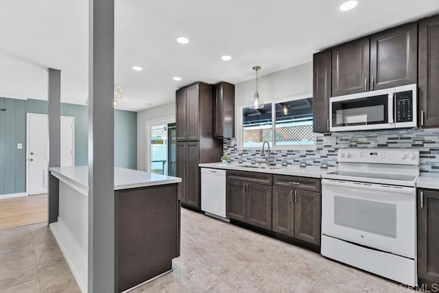 kitchen with a sink, white appliances, dark brown cabinetry, light countertops, and decorative backsplash